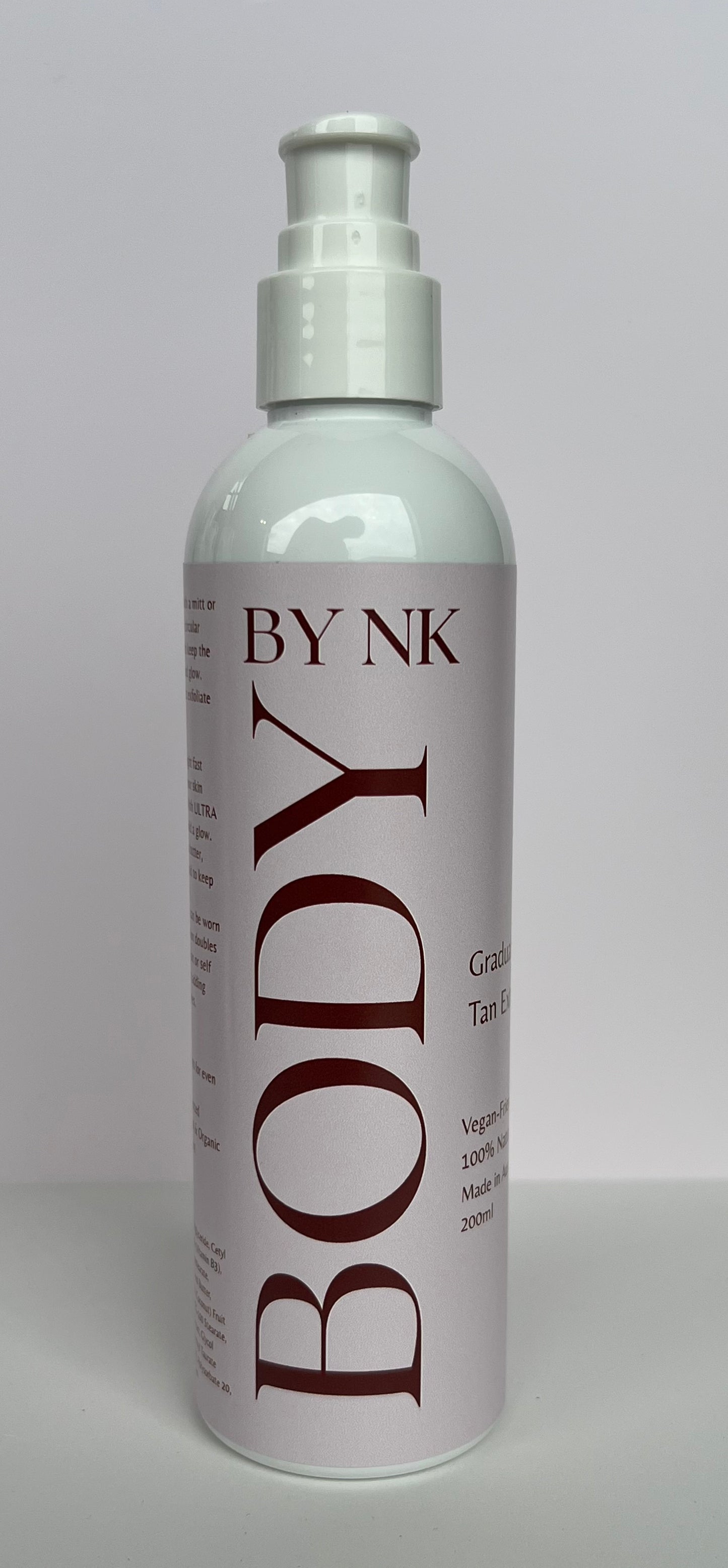 White bottle labeled 'BY NK Body' on a gray background