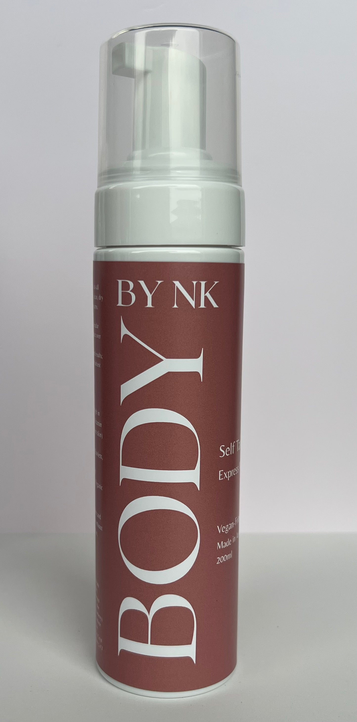 Skincare bottle labeled 'BY NK Body' on a gray background