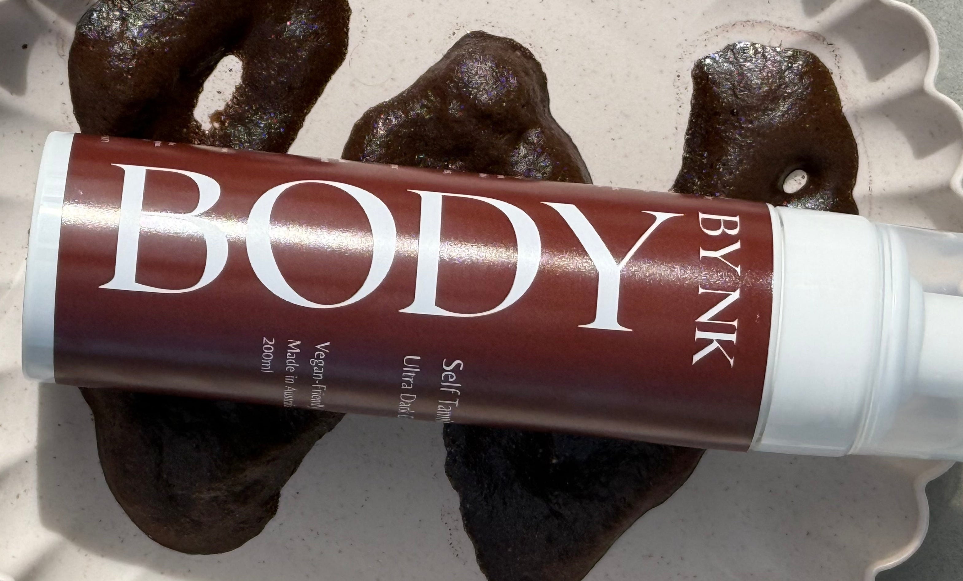 BYNK Body self-tanning product on a textured surface