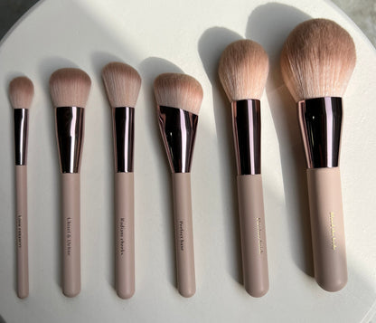 Set of makeup brushes on a round white plate with a neutral background