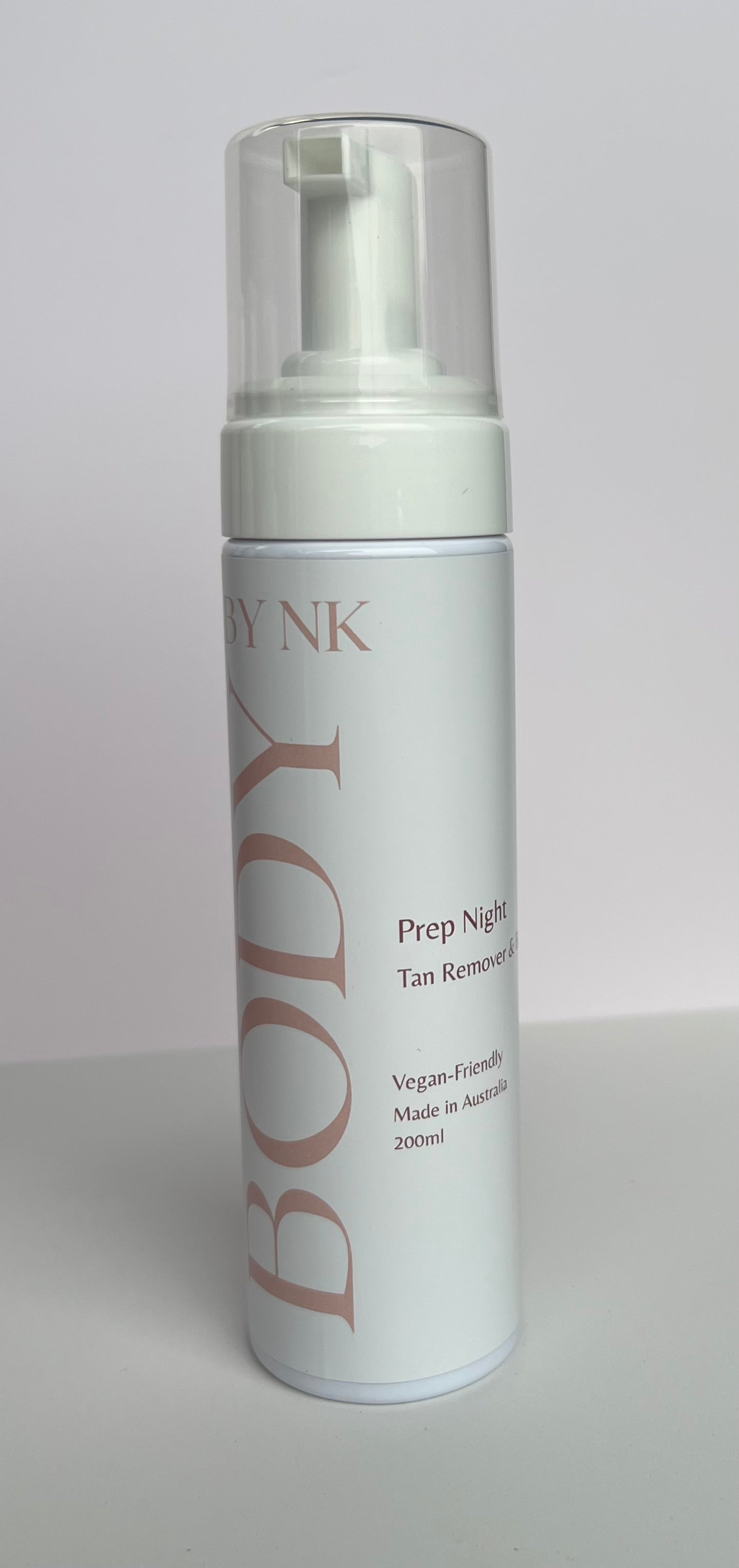 Foam bottle labeled 'BODY by NK' on a gray background